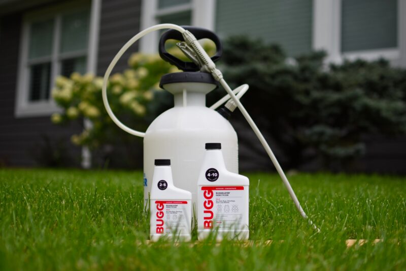 Bottles of insecticide concentrate in front of a pump sprayer 